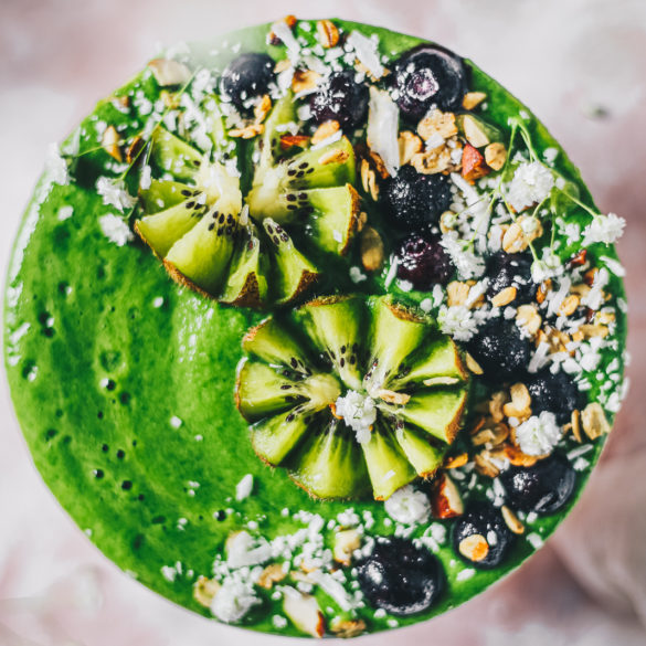 green smoothie bowl topped with kiwi and fruits