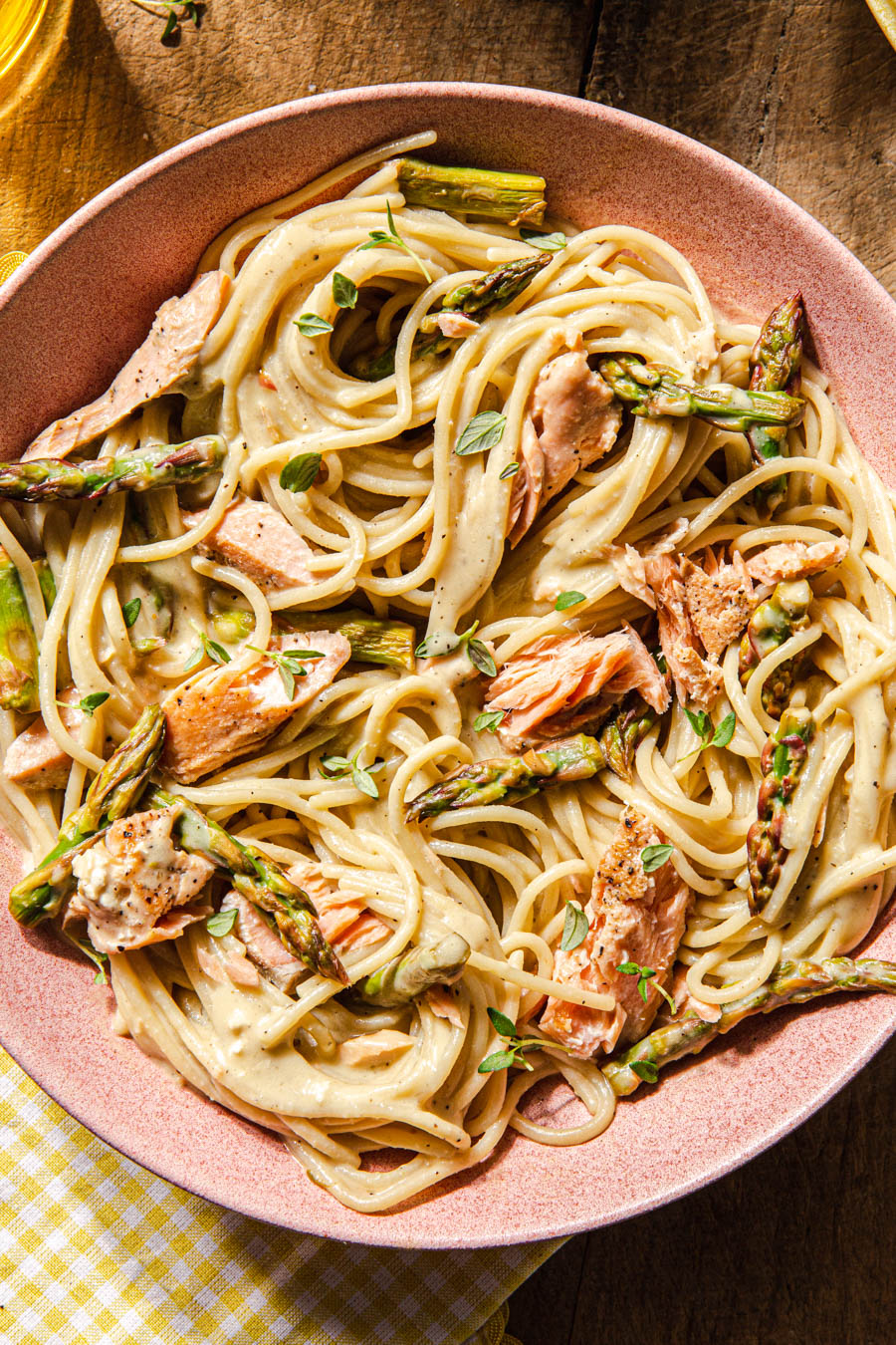 creamy pasta with salmon and asparagus in pink bowl