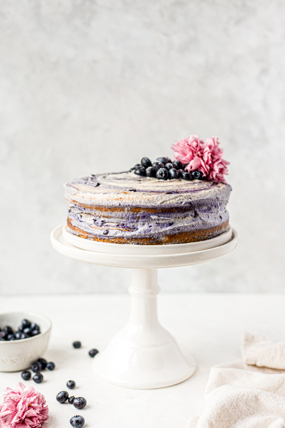Paleo Blueberry Cake with Cashew Frosting on a cake stand
