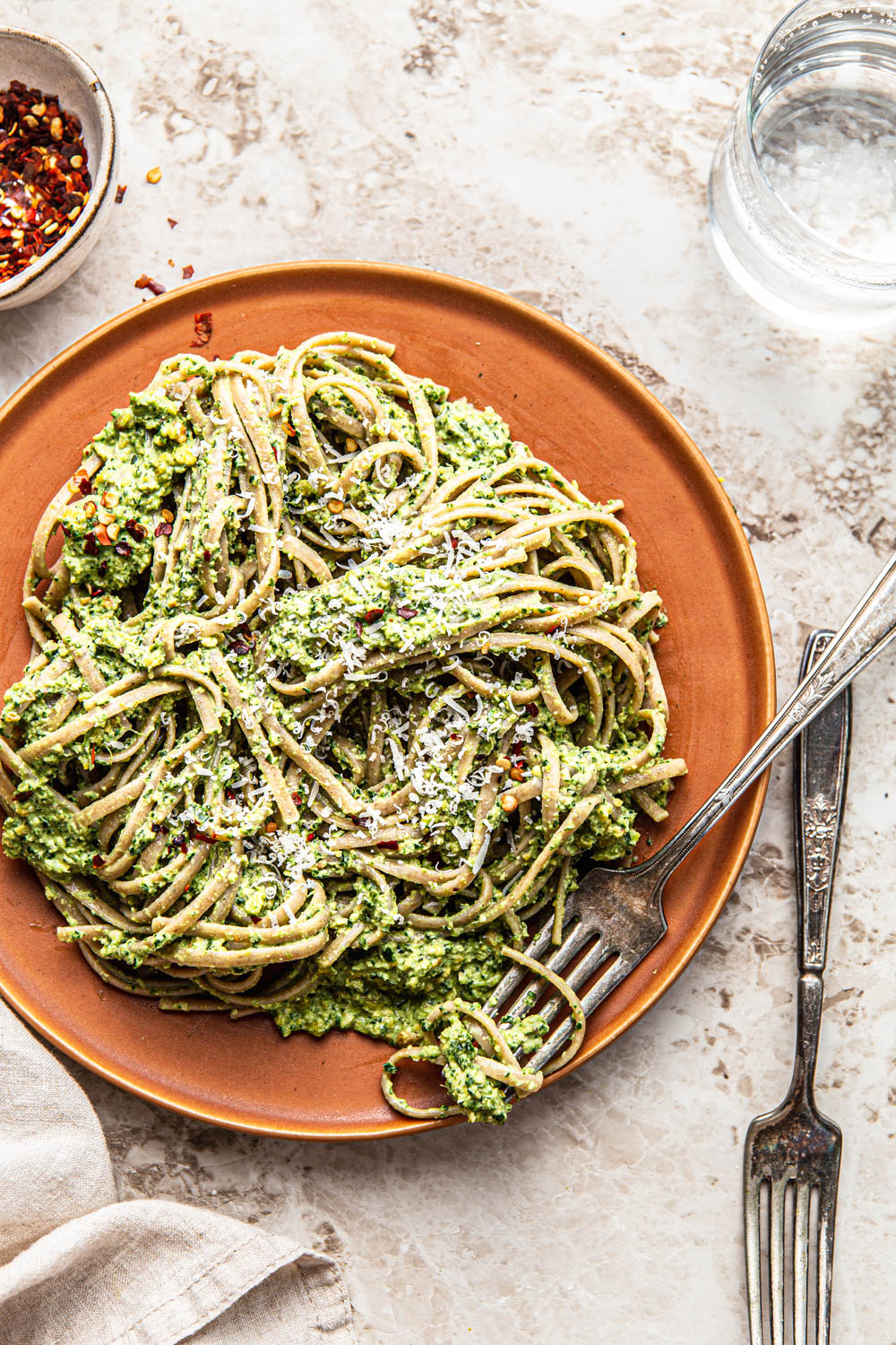 kale and pistachio pesto spaghetti with parmesan pasta swirled on a fork food photography