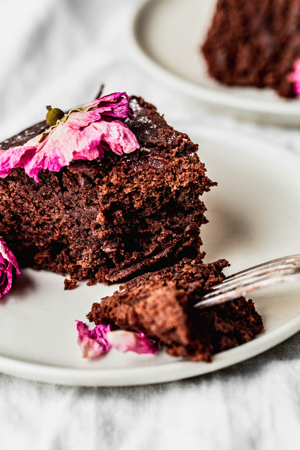 slice of moist chocolate cake with edible flowers food photography