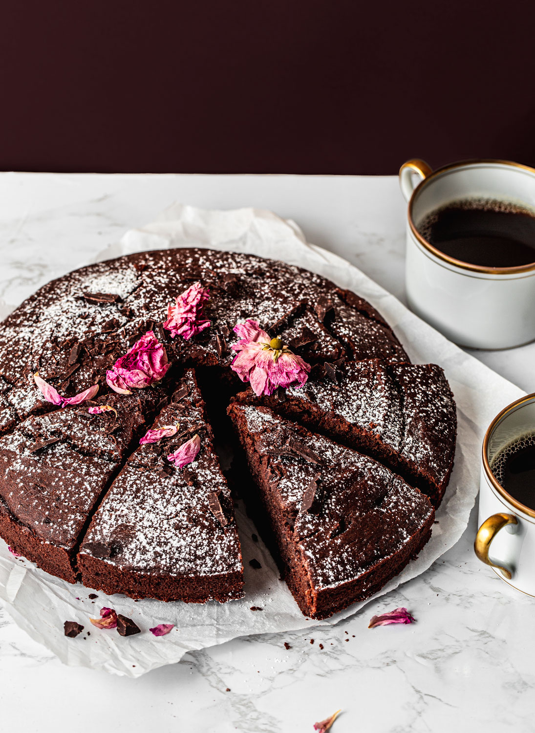 Moist Chocolate Date Cake with powdered sugar and edible dry flowers food photography(gluten-free)