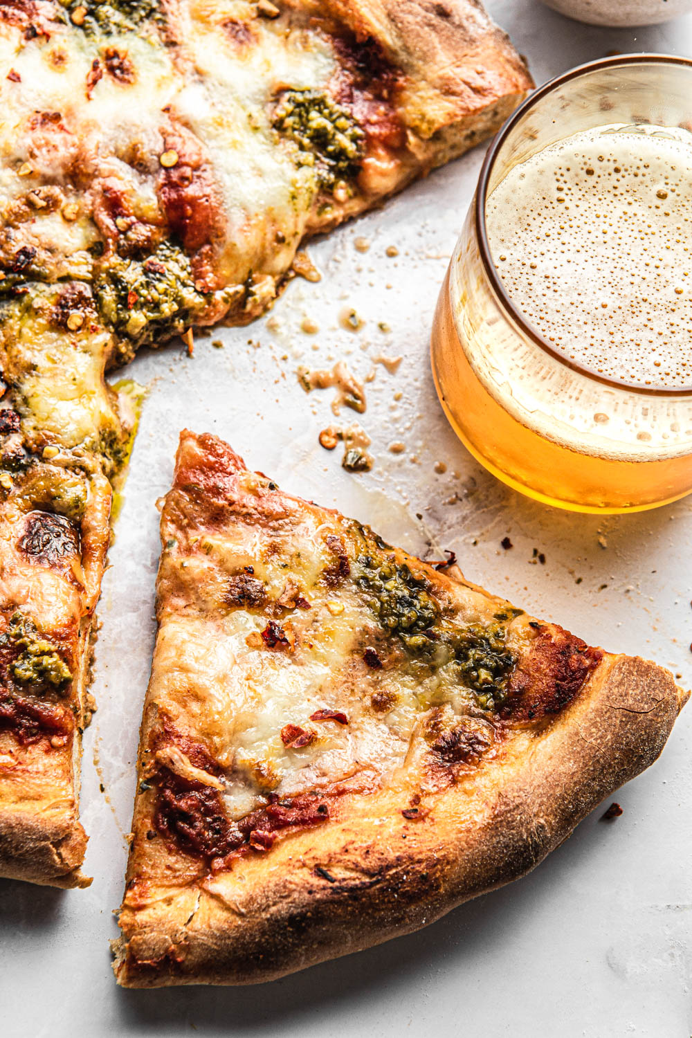 homemade pesto margherita pizza and glass of beer food photography