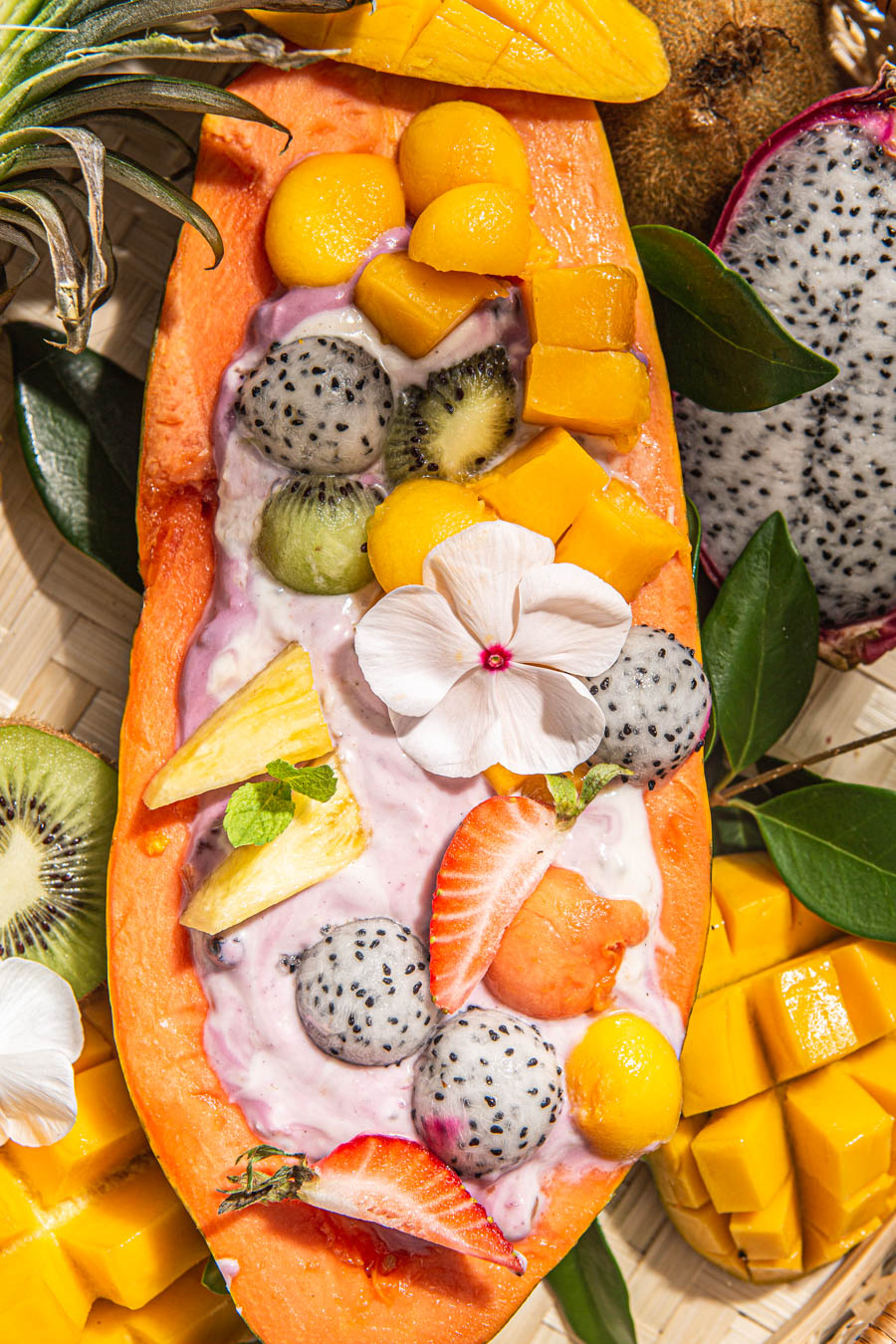 smoothie in papaya topped with fruits and flower
