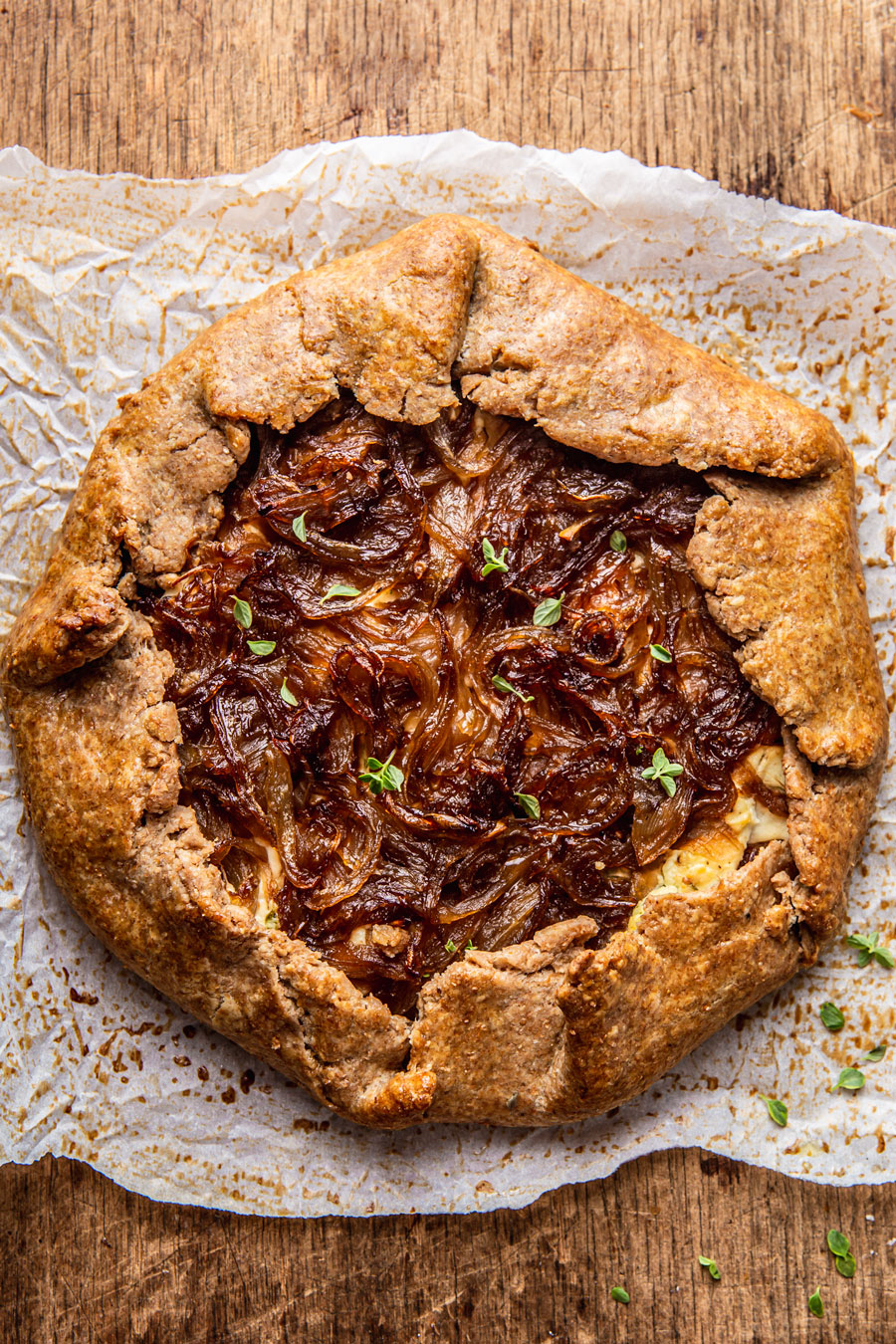 whole wheat galette with onions and thyme on a cutting board