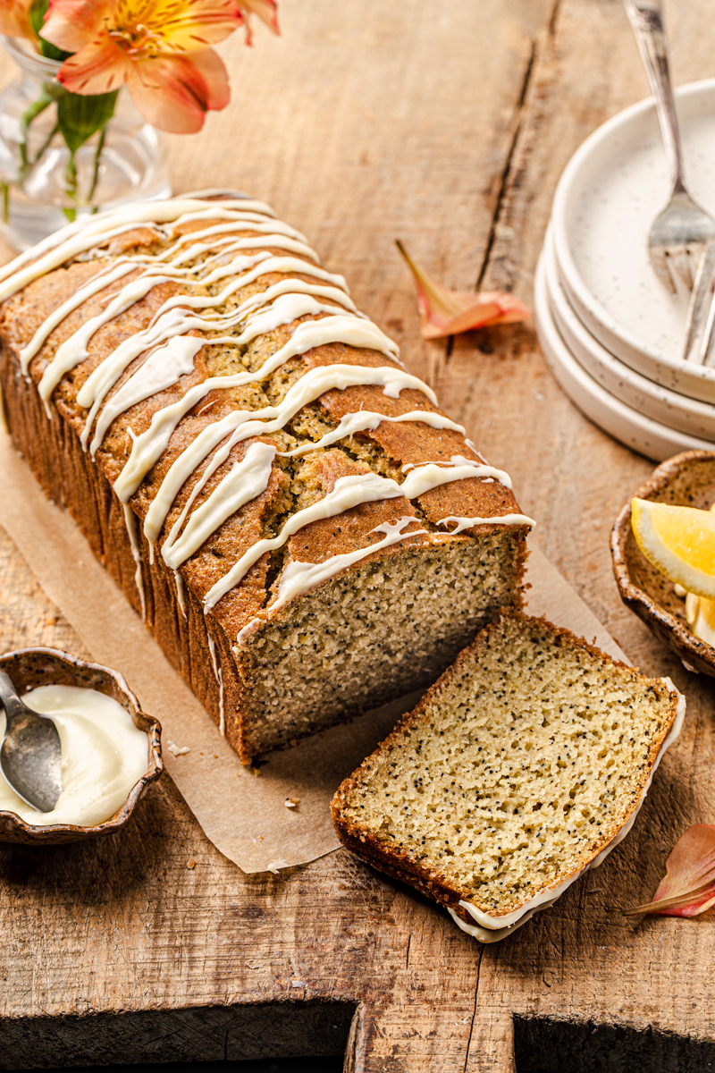 healthy lemon loaf with poppy seeds and white chocolate drizzle food photography
