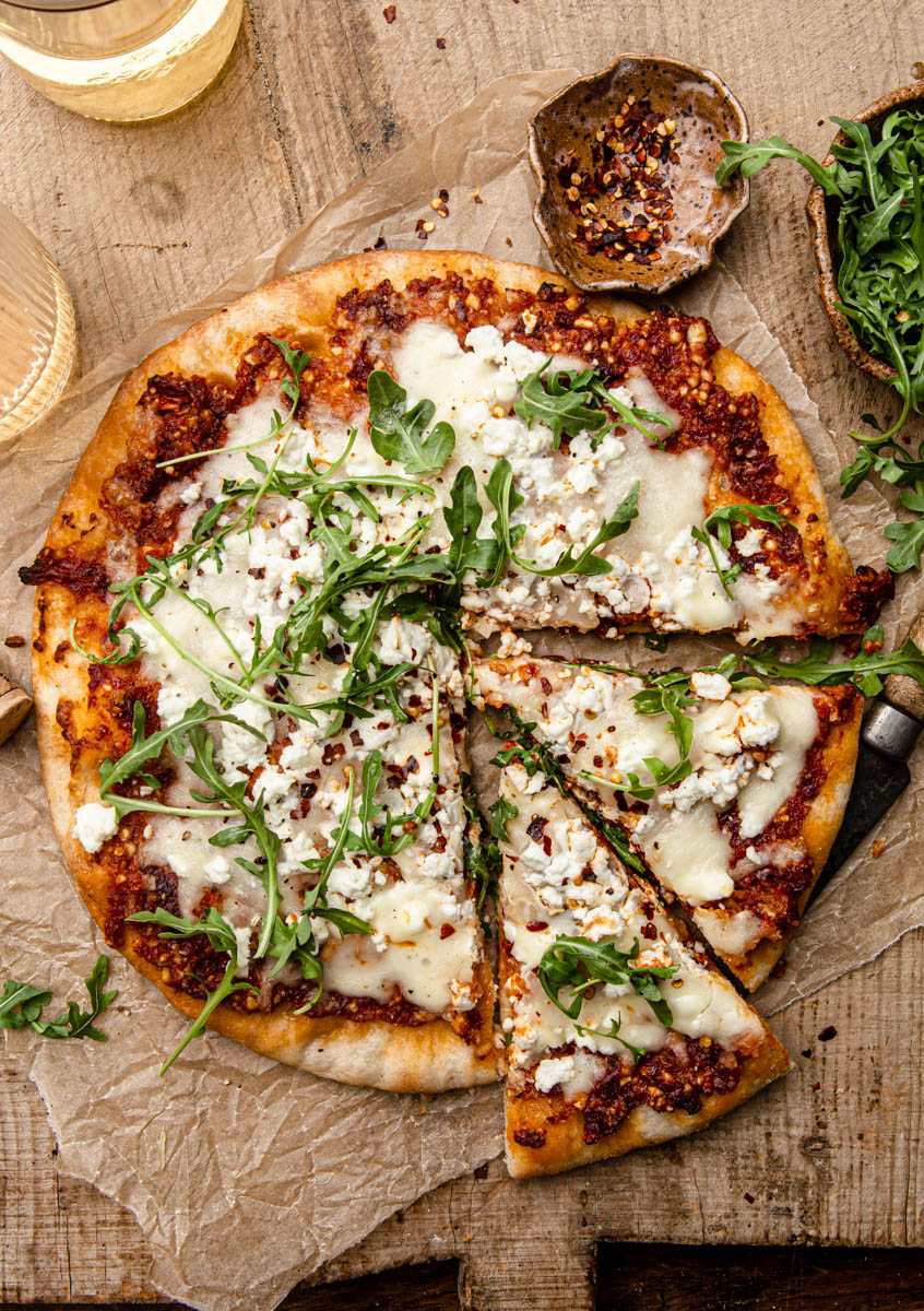 pizza with red pesto and arugula food photography
