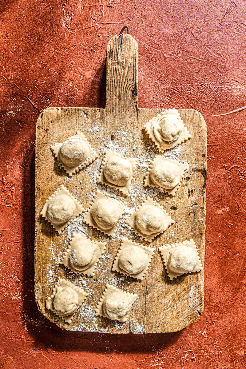 homemade ravioli with goat cheese on wooden board food photography
