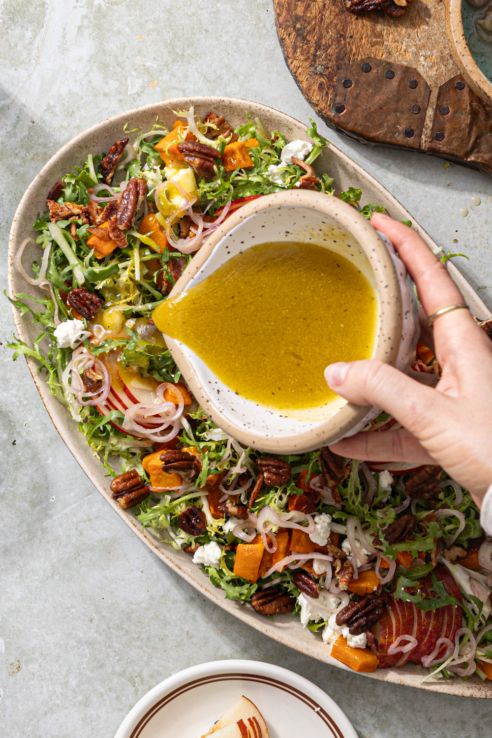 maple vinaigrette dressing pouring over a salad